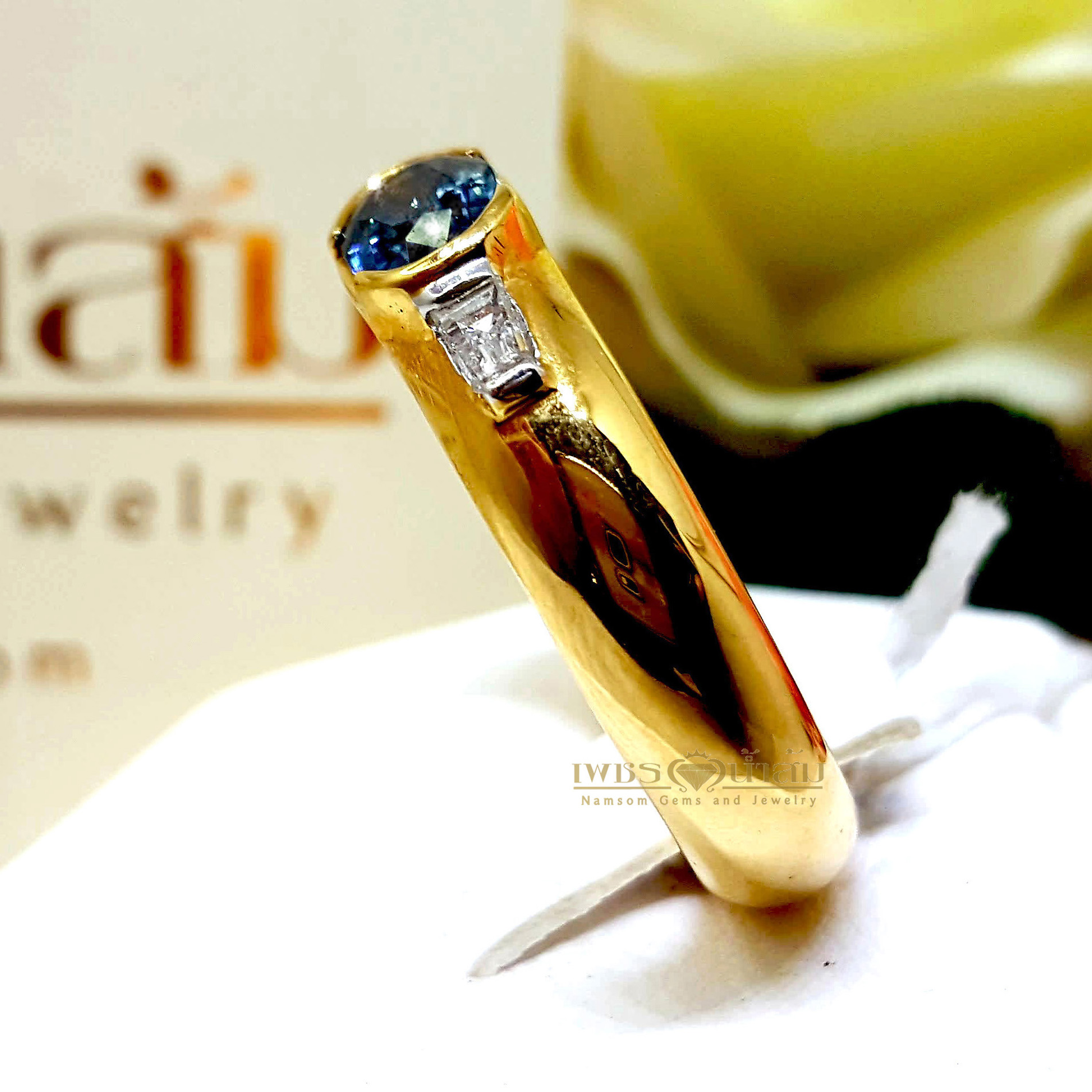 แหวนพลอยไพลิน Blue Sapphire สีสดเนื้องาม ประดับตกแต่งด้วยเพชรแท้บ่าข้างเจียรเหลี่ยมแบเก็ต Baguette บนตัวเรือนทองแท้ทั้งตัวเรือน