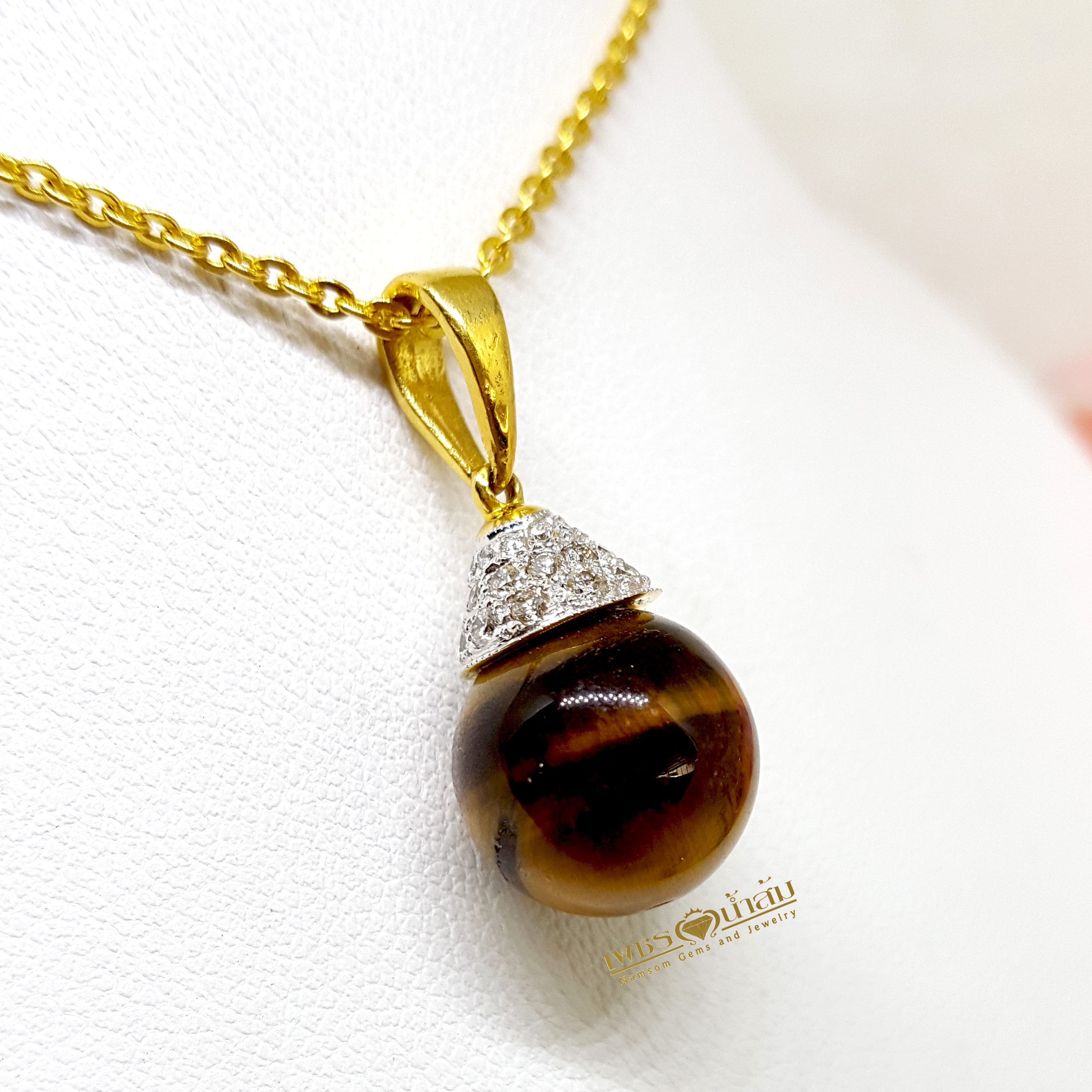 จี้ไทเกอร์อาย Tiger’s Eye ทรงกลม เรียงร้อยประดับตกแต่งด้วยเพชรแท้รอบตัว กลิ้งไปตามการขยับของผู้สวมใส่