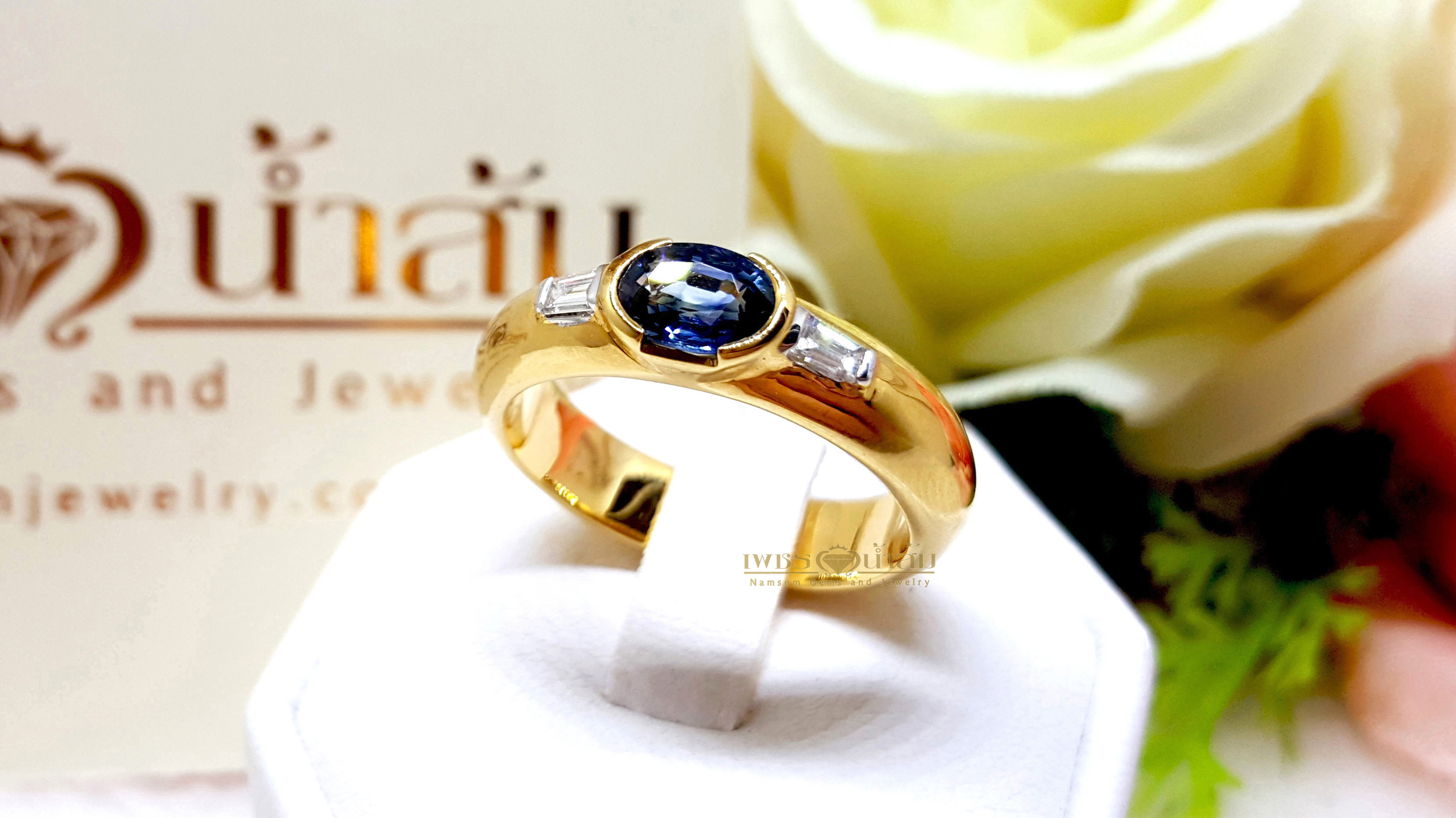 แหวนพลอยไพลิน Blue Sapphire สีสดเนื้องาม ประดับตกแต่งด้วยเพชรแท้บ่าข้างเจียรเหลี่ยมแบเก็ต Baguette บนตัวเรือนทองแท้ทั้งตัวเรือน