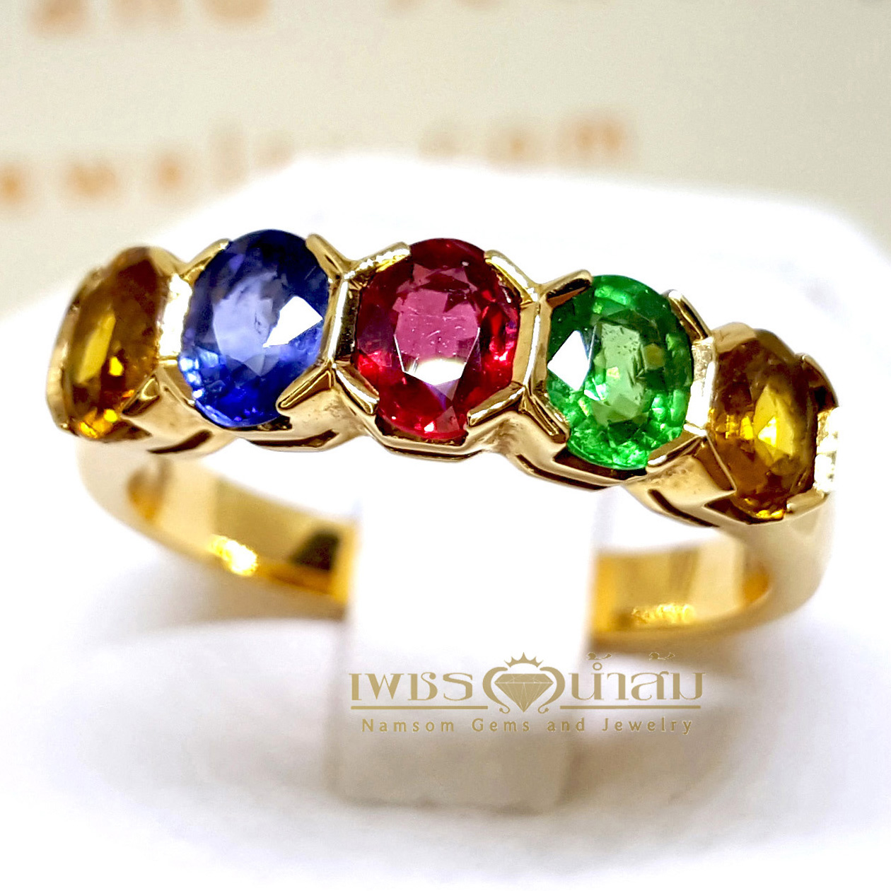 แหวนพลอยนพเก้าทรงปอกมีดสลับสี ประกอบไปด้วย ทับทิม ไพลิน บุษราคัม และมรกตสีสวย บนตัวเรือนทองทั้งตัวเรือน