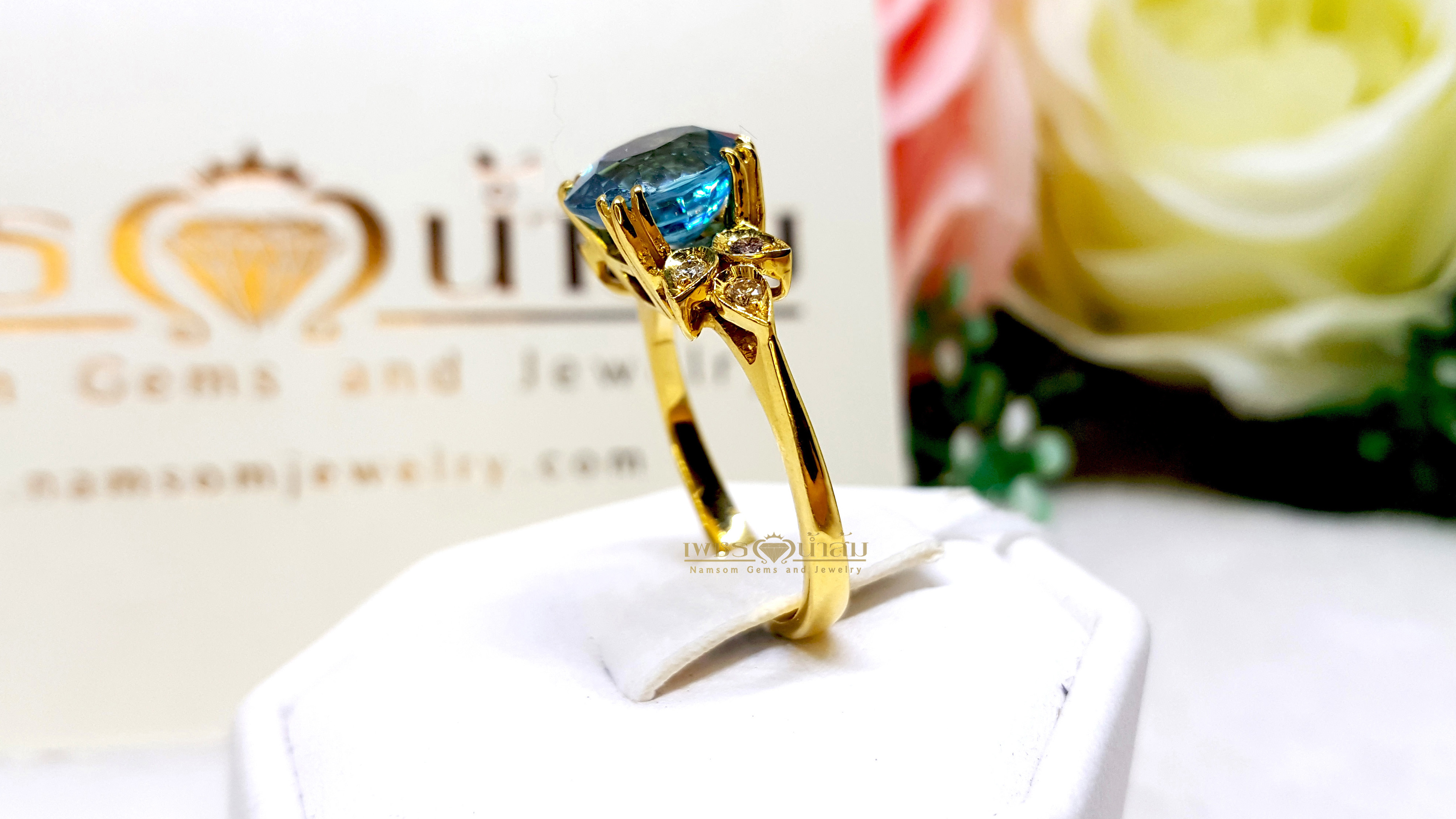 แหวนเพทาย Blue Zircon สีฟ้าสด เล่นลูกเล่นลายไทยทรงดอกประดับฝังด้วยเพชรแท้ บนตัวเรือนทองแท้ทั้งตัวเรือน