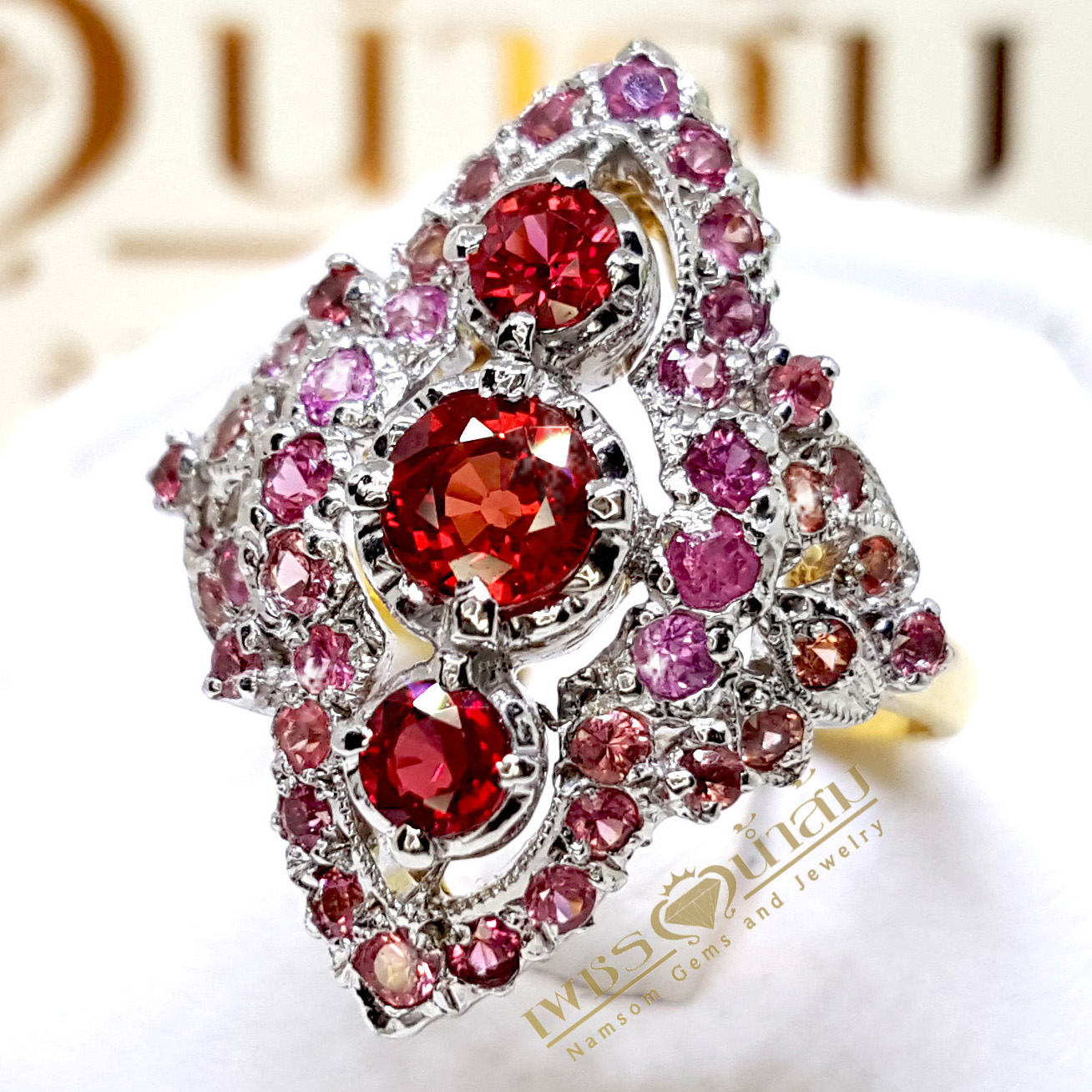 แหวนทับทิม Ruby สีแดงสดเรียงแถวสามเม็ด ประดับตกแต่งด้วย Pink Sapphire ตัวเรือนทรงไทยชุบทองคำขาว บนตัวเรือนทองแท้ทั้งตัวเรือน