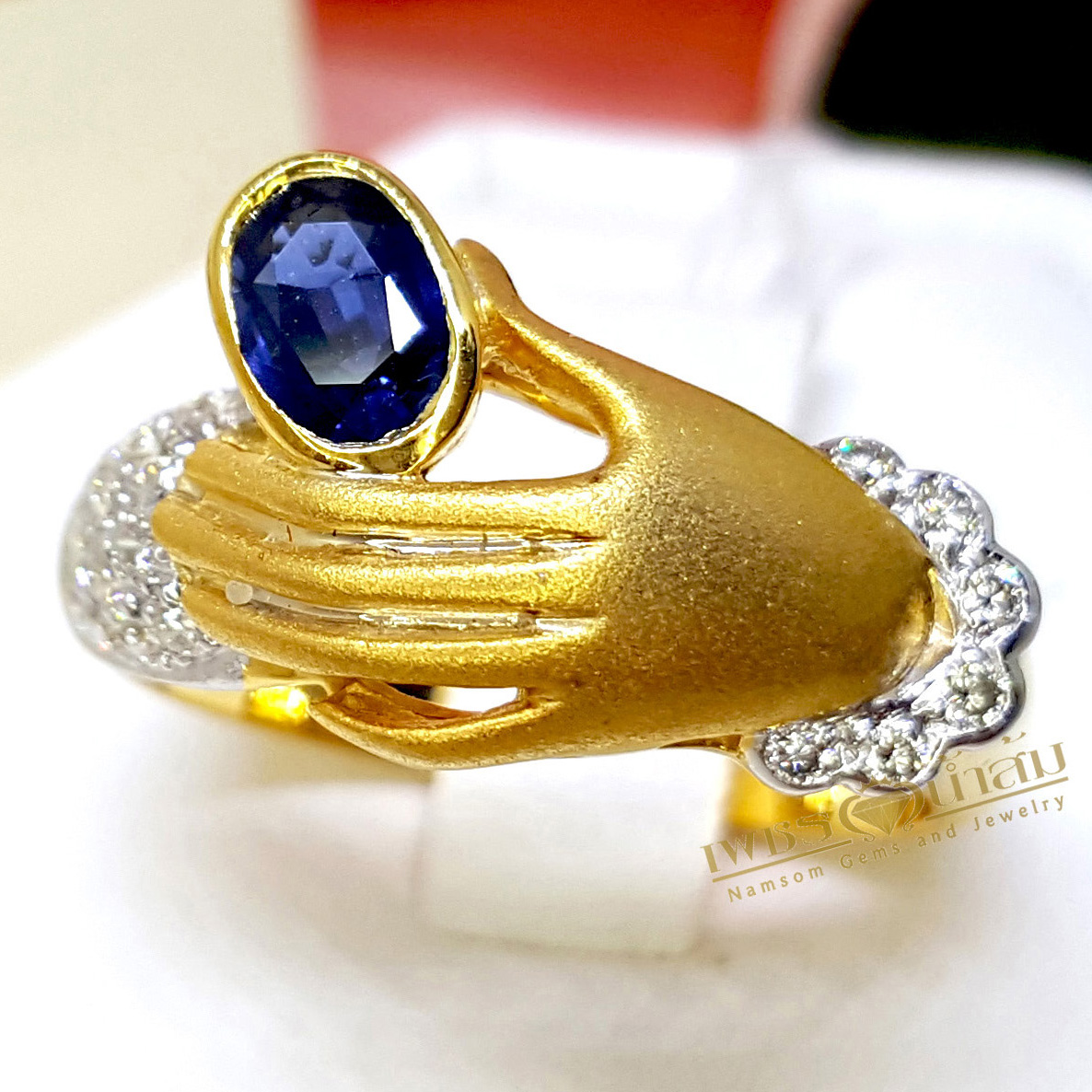 แหวนพลอยไพลิน Blue Sapphire สีสวย ออกแบบให้เป็นทรงมือจับ ประดับข้อมือด้วยเพชรแท้ ฝังจิกไข่ปลา บนตัวเรือนทองแท้ทั้งตัวเรือน