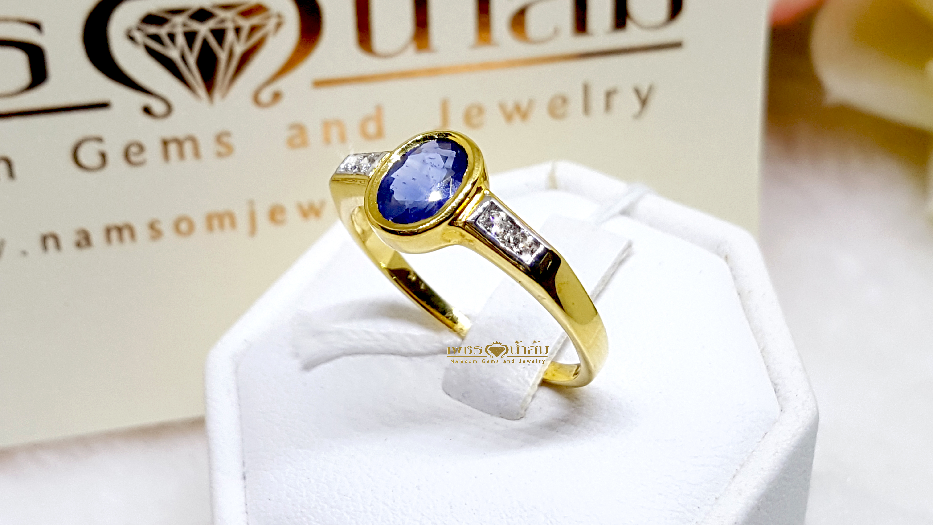 แหวนพลอยไพลิน Blue Sapphire เล่นไฟน้ำงามฝังหุ้ม ตกแต่งเพชรแท้ที่บ่าข้าง ดูเรียบหรู บนตัวเรือนทองแท้ทั้งตัวเรือน