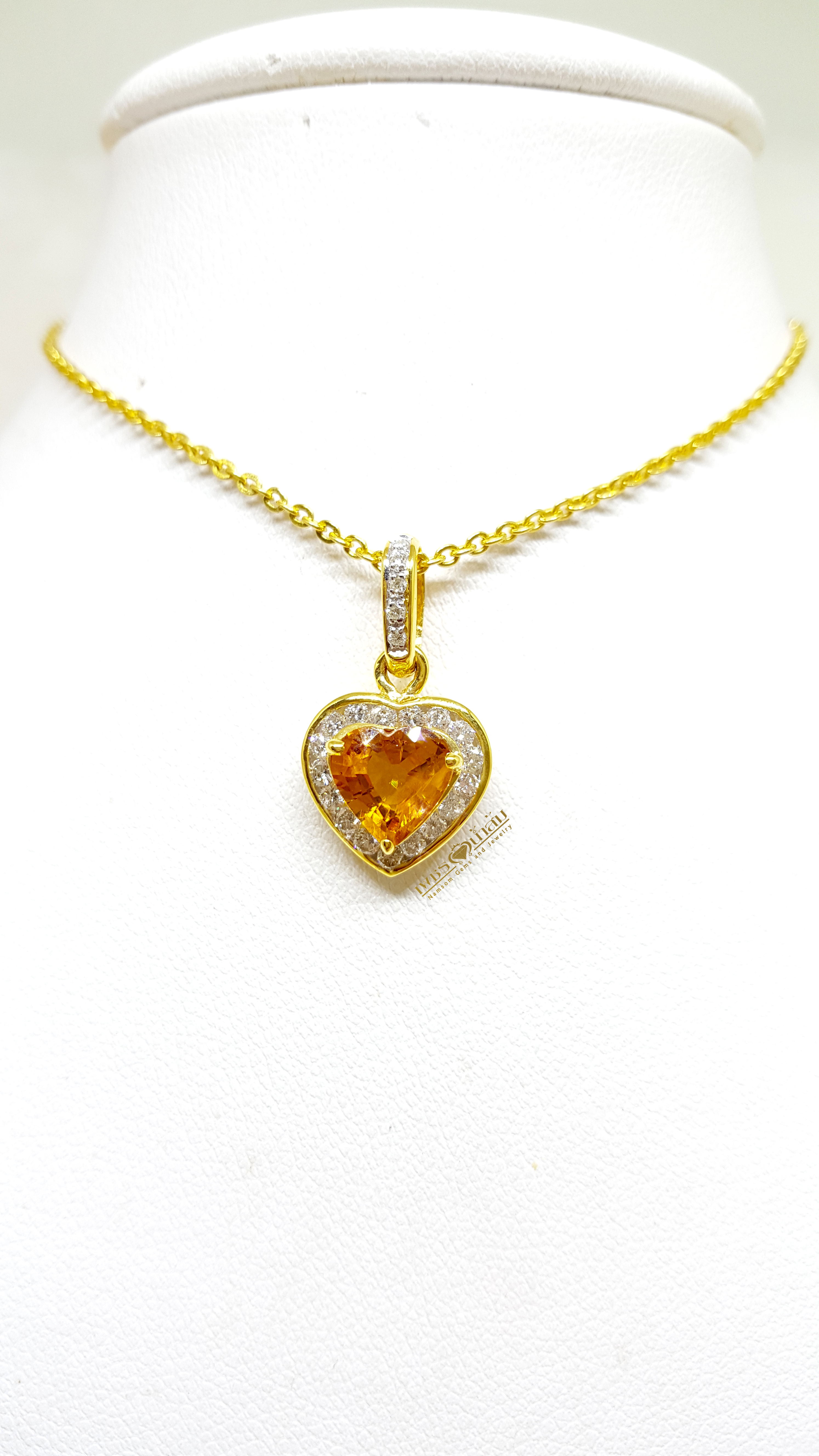 จี้บุษราคัม Yellow Sapphire ล้อมเพชรรอบตัวเรือน ตัวบุษราคัมเจียรระไนทรงหัวใจ ดูสวยหวานน่ารัก ออกมาเป็นผลงานที่งามร่วมสมัยเหนือกาลเวลา