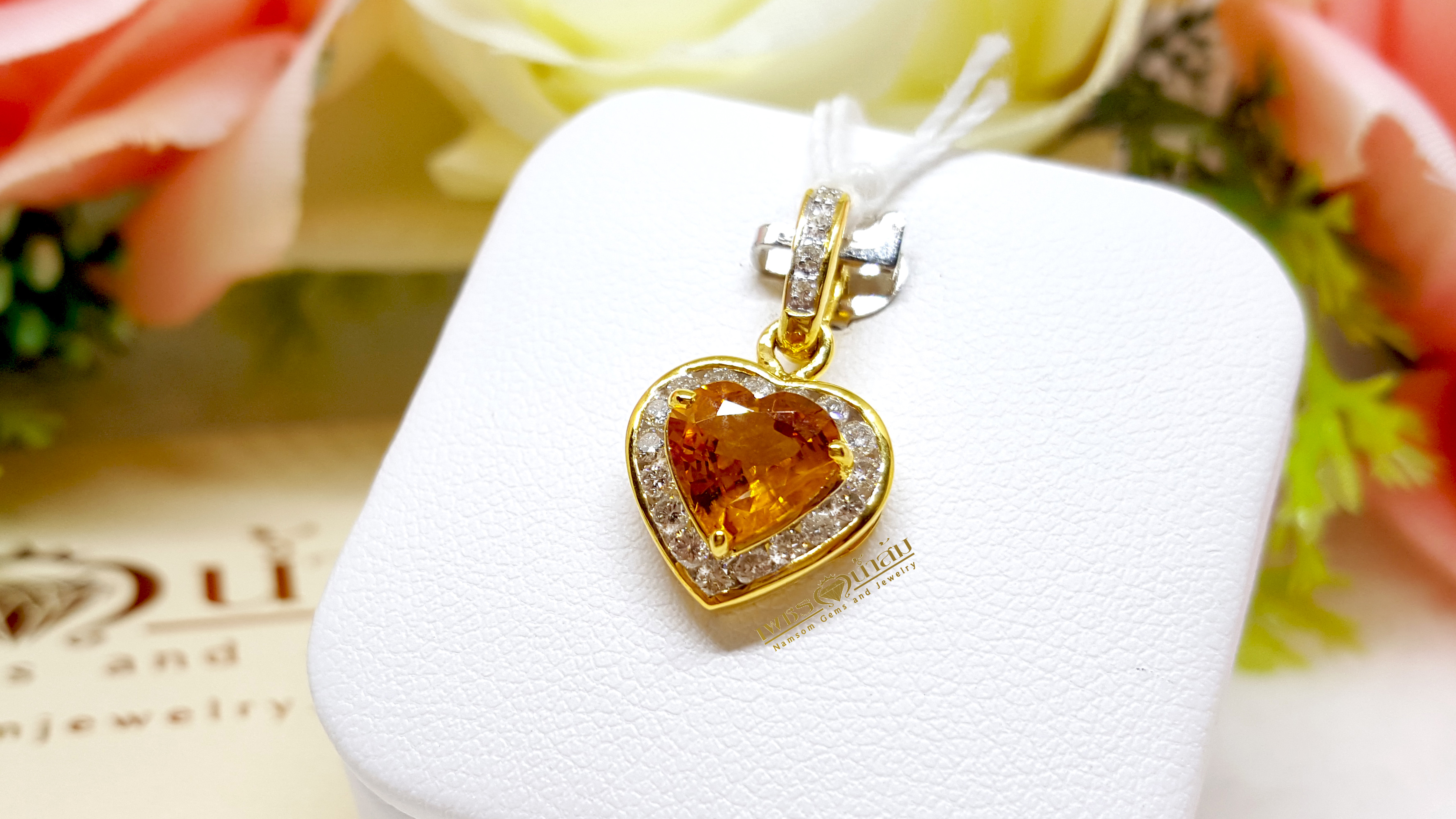 จี้บุษราคัม Yellow Sapphire ล้อมเพชรรอบตัวเรือน ตัวบุษราคัมเจียรระไนทรงหัวใจ ดูสวยหวานน่ารัก ออกมาเป็นผลงานที่งามร่วมสมัยเหนือกาลเวลา