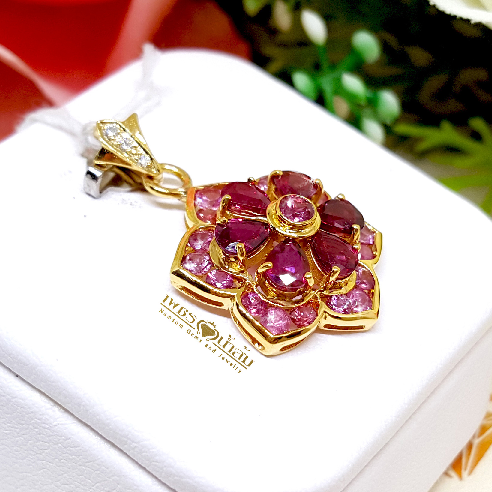 จี้พลอยทับทิม Ruby สีหวาน ประดับตกแต่งล้อมรอบด้วย Pink Sapphire ออกแบบเป็นรูปทรงดอกไม้ เย้ายวนทุกสายตา
