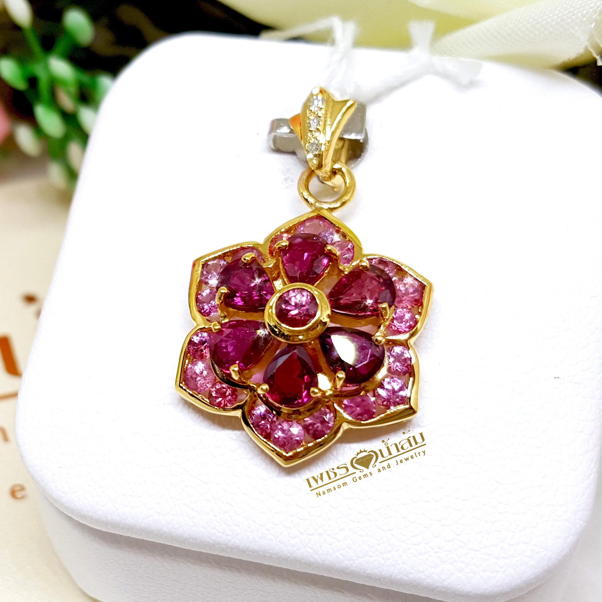 จี้พลอยทับทิม Ruby สีหวาน ประดับตกแต่งล้อมรอบด้วย Pink Sapphire ออกแบบเป็นรูปทรงดอกไม้ เย้ายวนทุกสายตา