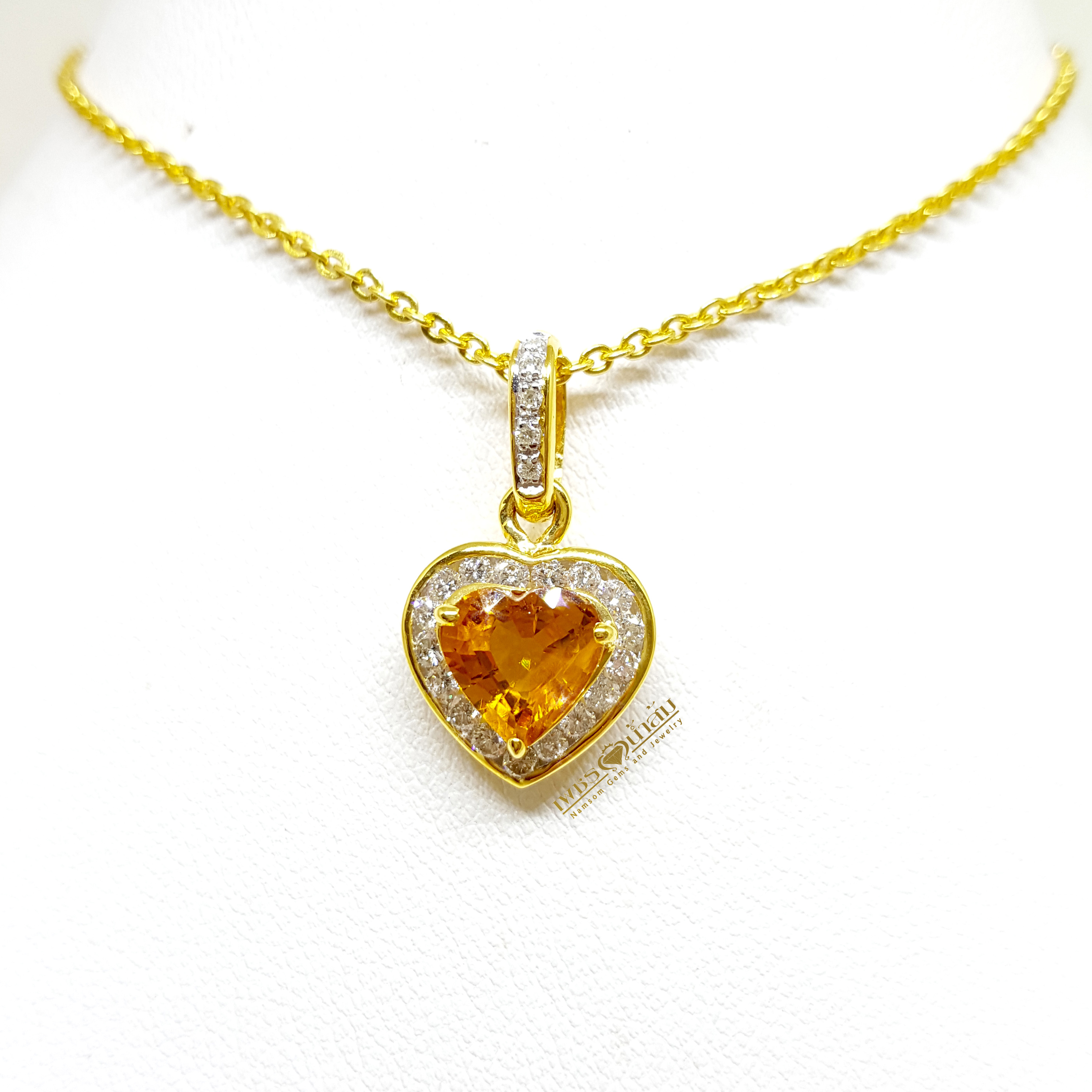 จี้บุษราคัม Yellow Sapphire ล้อมเพชรรอบตัวเรือน ตัวบุษราคัมเจียรระไนทรงหัวใจ ดูสวยหวานน่ารัก ออกมาเป็นผลงานที่งามร่วมสมัยเหนือกาลเวลา