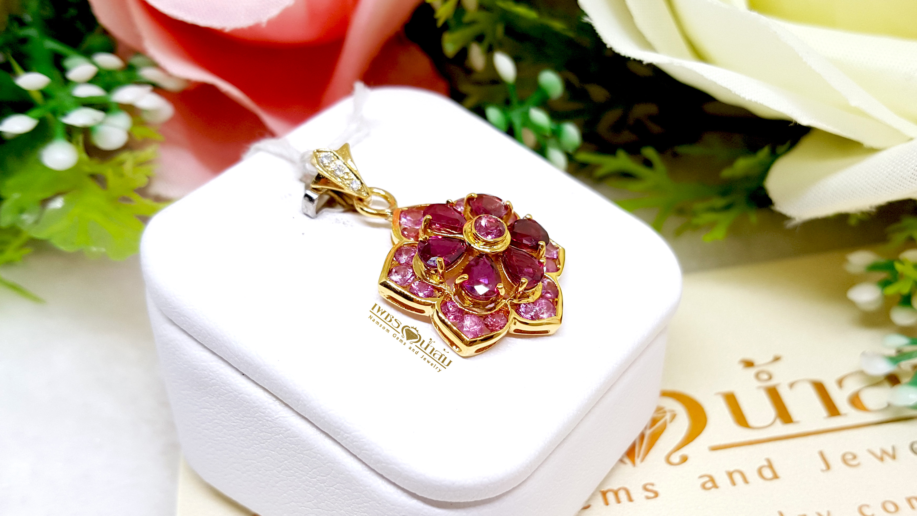 จี้พลอยทับทิม Ruby สีหวาน ประดับตกแต่งล้อมรอบด้วย Pink Sapphire ออกแบบเป็นรูปทรงดอกไม้ เย้ายวนทุกสายตา