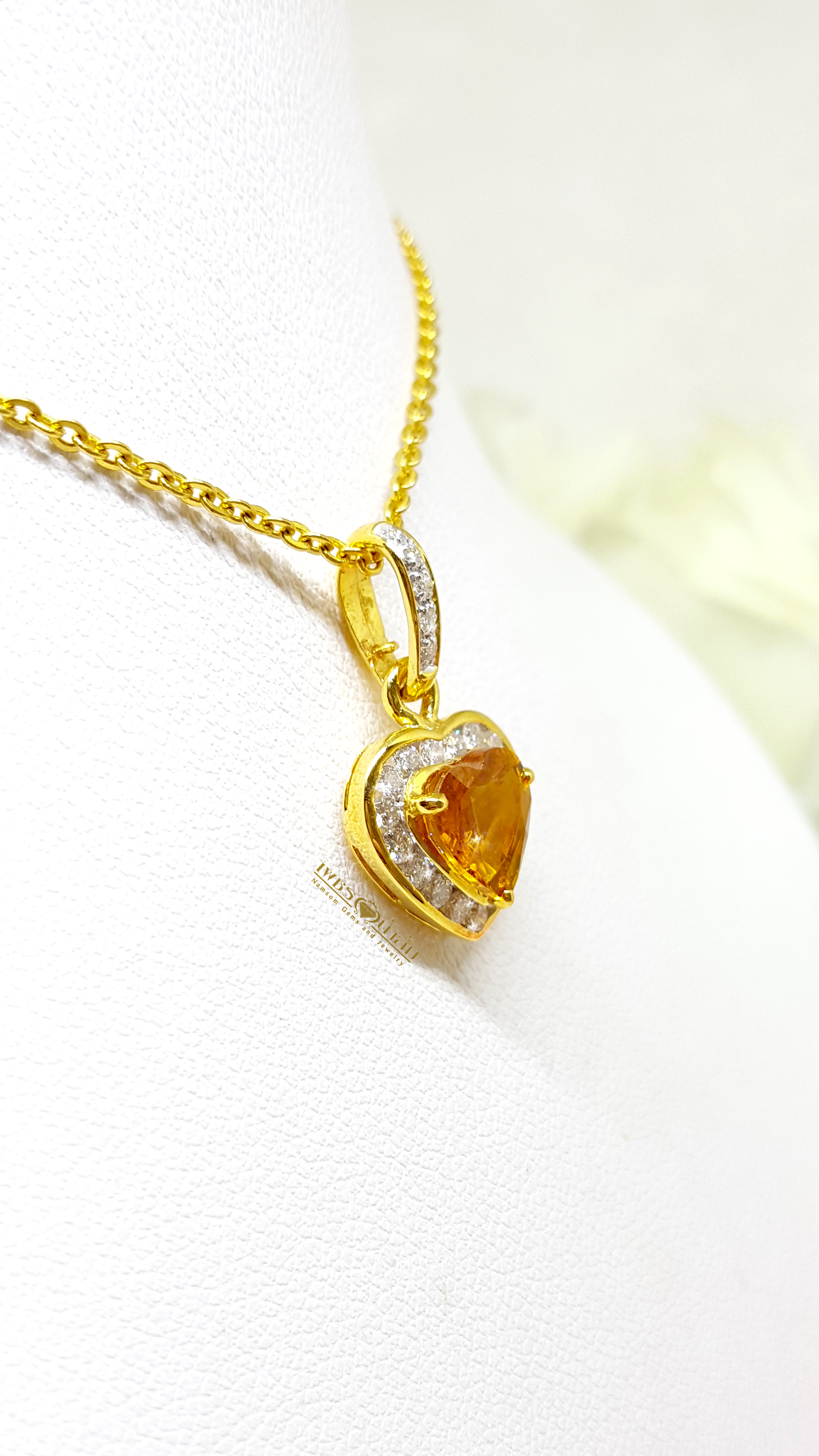 จี้บุษราคัม Yellow Sapphire ล้อมเพชรรอบตัวเรือน ตัวบุษราคัมเจียรระไนทรงหัวใจ ดูสวยหวานน่ารัก ออกมาเป็นผลงานที่งามร่วมสมัยเหนือกาลเวลา