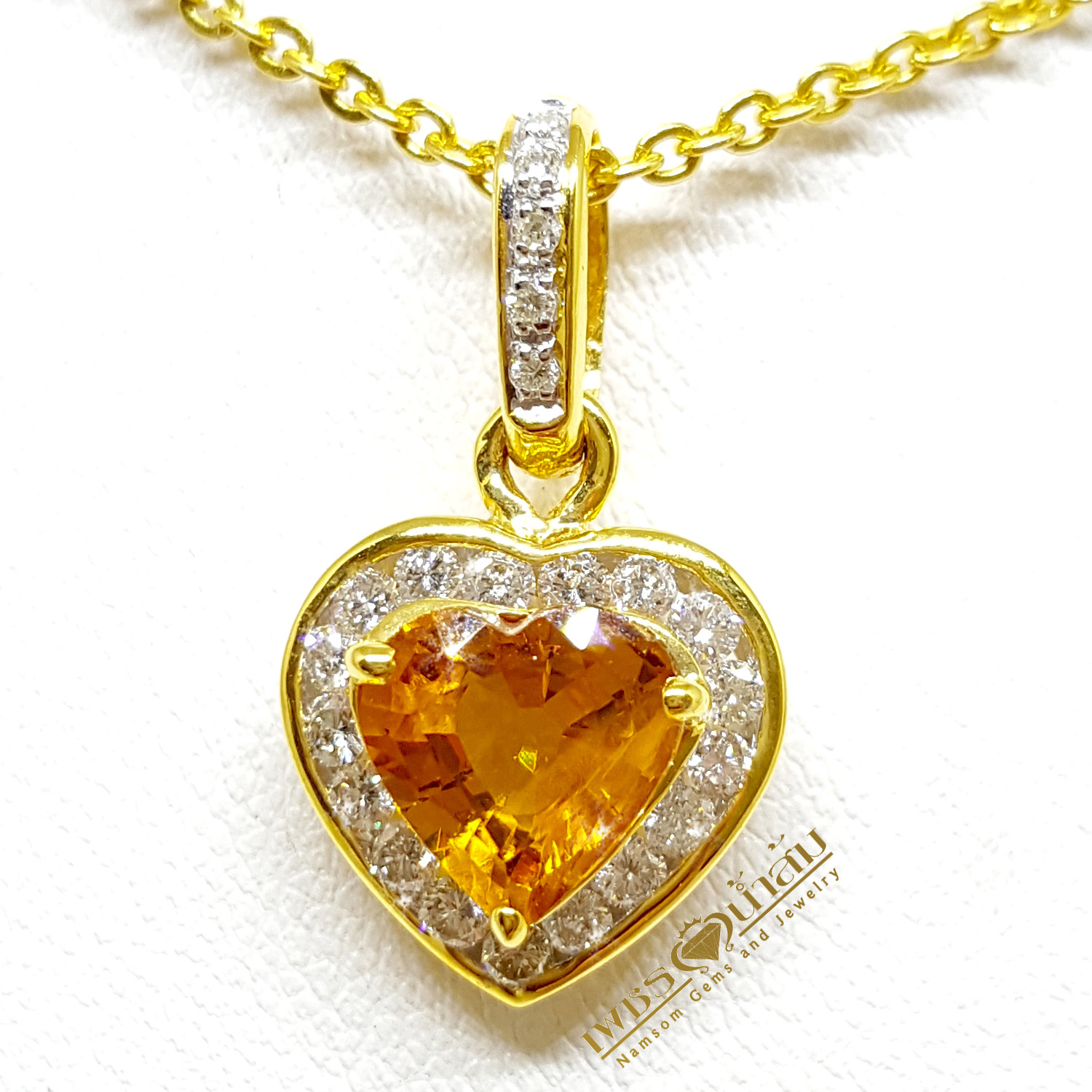 จี้บุษราคัม Yellow Sapphire ล้อมเพชรรอบตัวเรือน ตัวบุษราคัมเจียรระไนทรงหัวใจ ดูสวยหวานน่ารัก ออกมาเป็นผลงานที่งามร่วมสมัยเหนือกาลเวลา