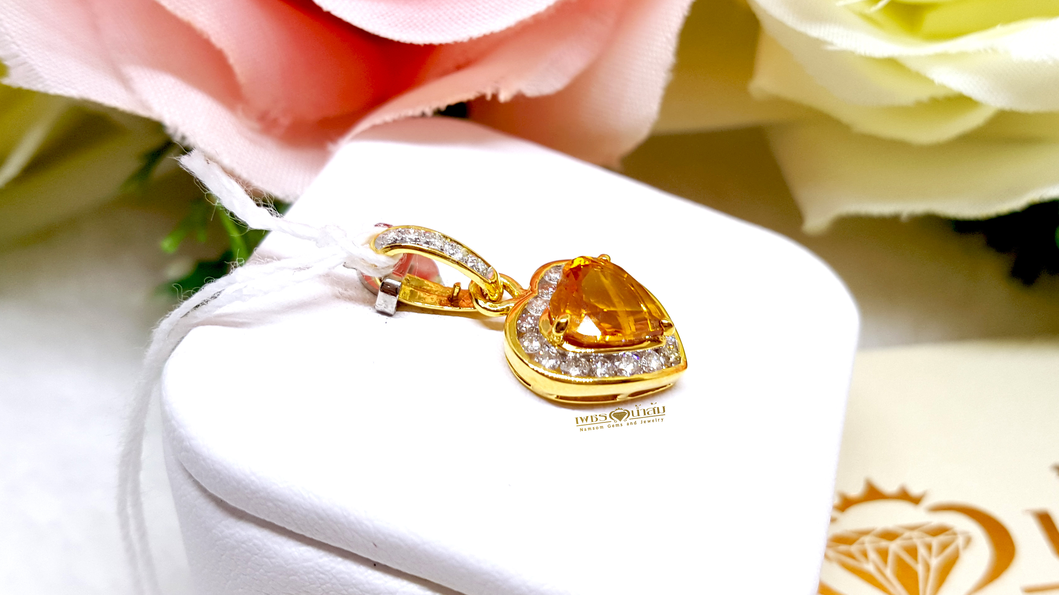 จี้บุษราคัม Yellow Sapphire ล้อมเพชรรอบตัวเรือน ตัวบุษราคัมเจียรระไนทรงหัวใจ ดูสวยหวานน่ารัก ออกมาเป็นผลงานที่งามร่วมสมัยเหนือกาลเวลา