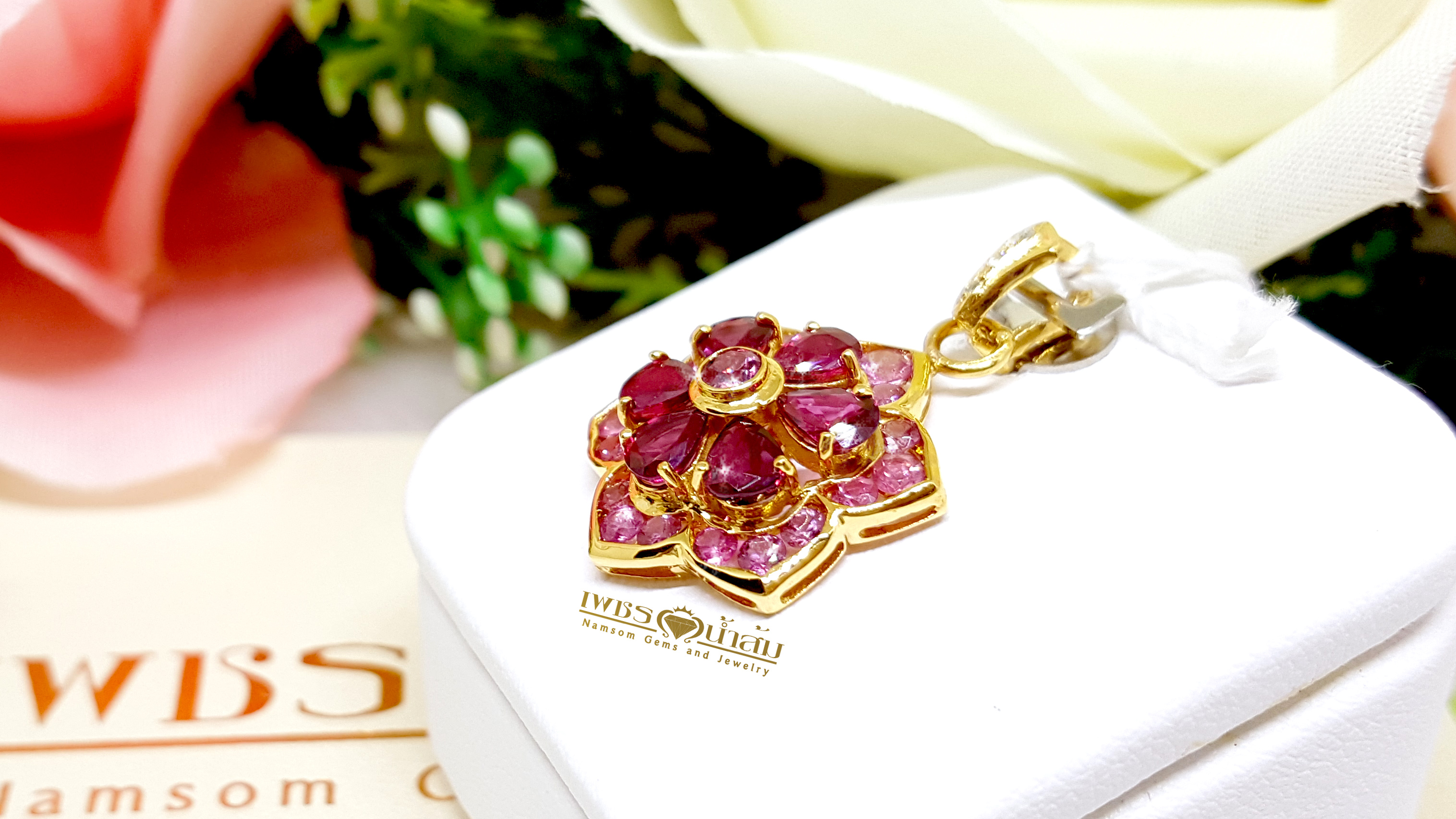 จี้พลอยทับทิม Ruby สีหวาน ประดับตกแต่งล้อมรอบด้วย Pink Sapphire ออกแบบเป็นรูปทรงดอกไม้ เย้ายวนทุกสายตา