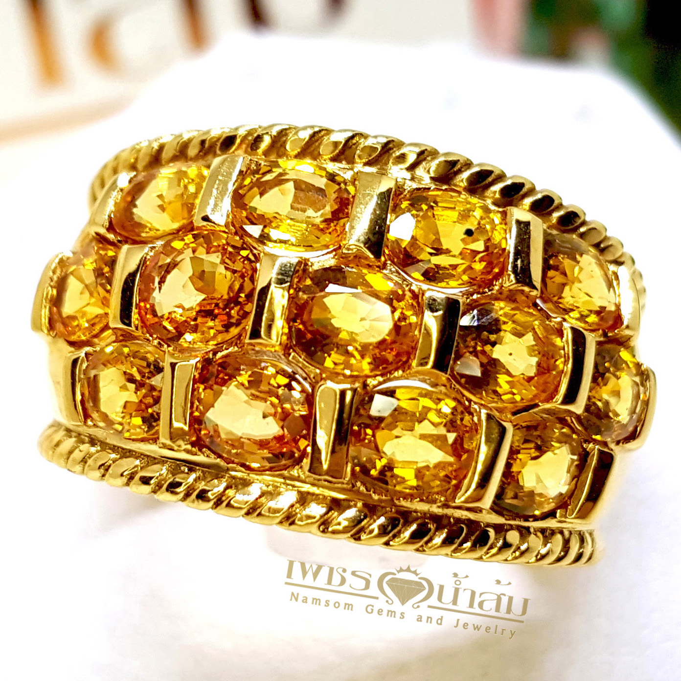 แหวนพลอยบุษราคัม Yellow Sapphire เล่นไฟน้ำงาม เป็นผลงานที่แสดงผีมืองและเทคนิคการฝังแบบเรียบไร้หนาม ของช่างเอกร้าน"เพชรน้ำส้ม"