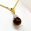 จี้ไทเกอร์อาย Tiger’s Eye ทรงกลม เรียงร้อยประดับตกแต่งด้วยเพชรแท้รอบตัว กลิ้งไปตามการขยับของผู้สวมใส่